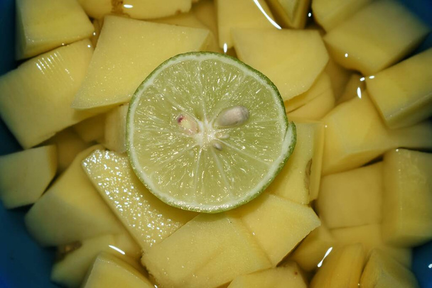 Hyderabad India - 10 de marzo de 2021: Ingredientes en rodajas preparados para cocinar una sabrosa sopa de papas con rodajas de limón. - Foto, imagen