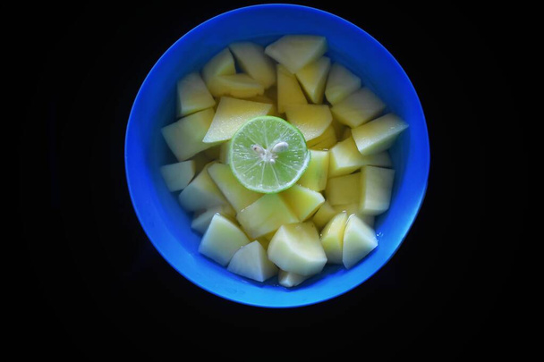 Нарезанные ингредиенты готовят вкусный картофельный суп со слайсом лемона. - Фото, изображение