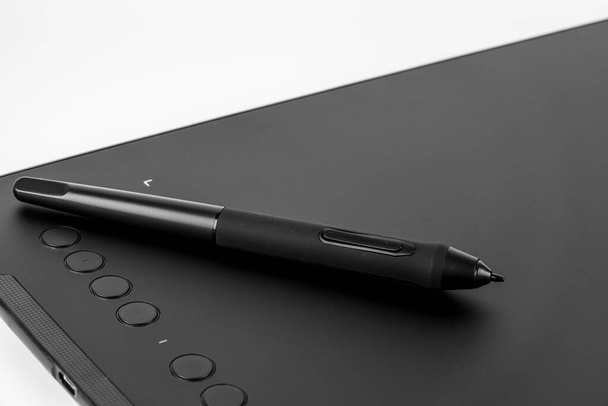 Black graphic tablet with pen for illustrators, designers and photographers, isolated on white background. - Foto, Imagem
