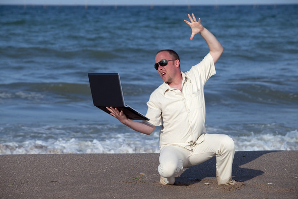 Csalódott napégette üzletember, a strandon a laptop - Fotó, kép