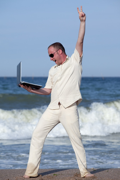 młody biznesmen na plaży z jego laptop zadowoleni z sukcesu - Zdjęcie, obraz