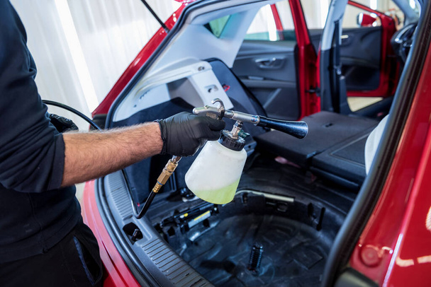 A car service worker cleans interiror with a special foam generator - Fotoğraf, Görsel