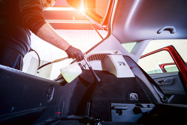 A car service worker cleans interiror with a special foam generator - Fotografie, Obrázek