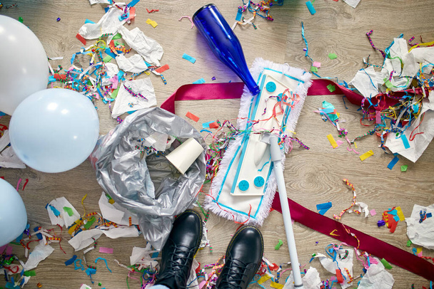 Жінка з пухнастим прибиранням безладу підлоги в кімнаті після вечірки конфетті, вранці після святкування вечірки, домашнього завдання, прибирання послуг
 - Фото, зображення