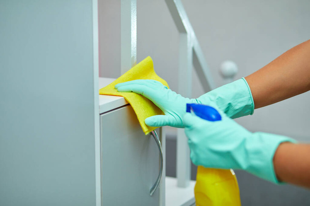 Bärtiger Mann reinigt Wohntischoberfläche mit Handtuch und Handschuhen, Desinfektionssprayflasche, bricht Geschlechterstereotype, geschlechtsneutral. - Foto, Bild