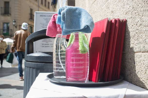 Bandeja de camarero llena de productos desinfectantes en la terraza del restaurante. Mediciones de Covid-19 en concepto de hostelería - Foto, Imagen