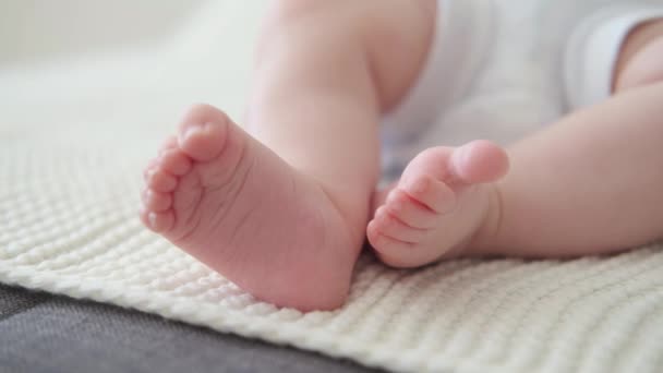 4k. Piccoli bambini piccoli piedi nudi su un plaid bianco. Neonato. Famiglia felice - Filmati, video