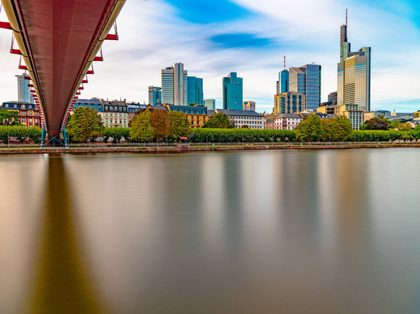 The Holbeinsteg in Frankfurt Germany with the river Main in foreground and the beautiful skyline in the background at sunset. - Foto, Imagen