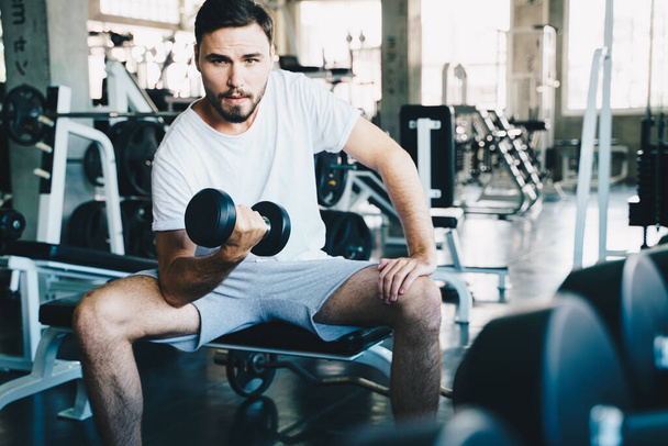 Wellness men lifting dumbbell weight hand in gym healthy life style - Φωτογραφία, εικόνα
