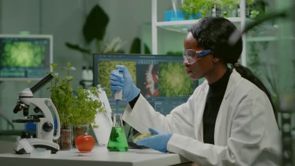 Biologiste scientifique femme africaine chercheuse prenant une solution génétique à partir d'une éprouvette - Séquence, vidéo