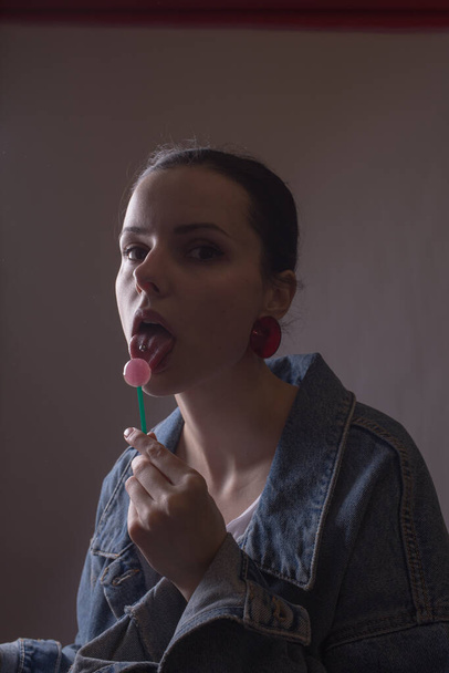 красивая девушка ест карамель на палочке - Фото, изображение