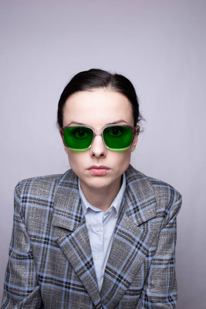 woman in green glasses and gray plaid suit - Foto, afbeelding