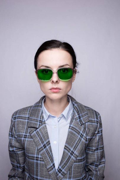 woman in green glasses and gray plaid suit - Fotó, kép