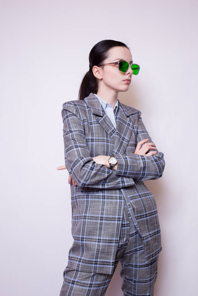 woman in green glasses and gray plaid suit - Foto, imagen