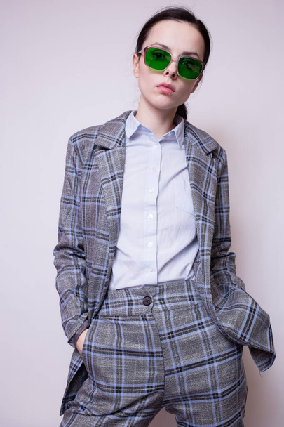 Frau mit grüner Brille und grau kariertem Anzug - Foto, Bild