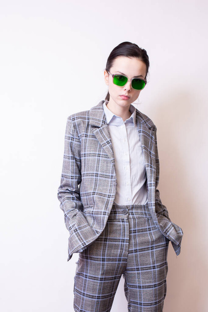 woman in green glasses and gray plaid suit - 写真・画像