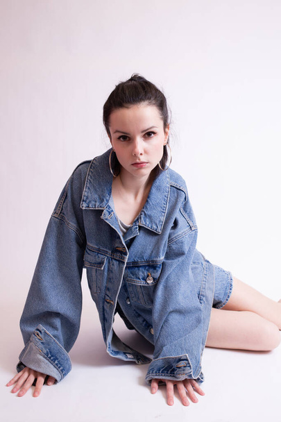woman in denim jacket and shorts, on white studio background - Fotografie, Obrázek