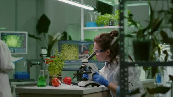 Lekarz biochemii badający badanie chemiczne przy użyciu mikroskopu - Materiał filmowy, wideo