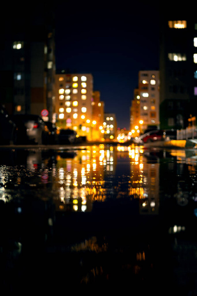 Gece hayatı, su birikintilerinde ışık yansıması olan başkentin modern binaları. Şehir manzarası, yağmurlu bir günde. - Fotoğraf, Görsel