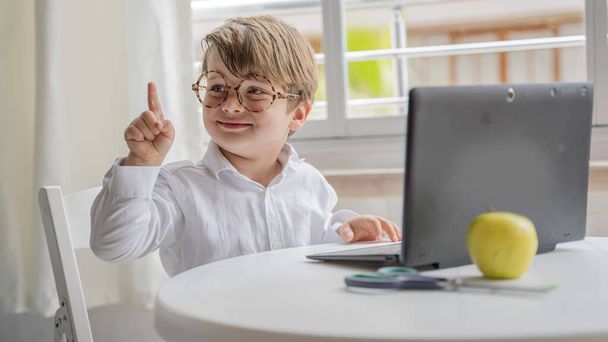 Junge benutzt Laptop und lernt zu Hause online. Hausaufgabenbetreuung, fernes Lernen - Foto, Bild