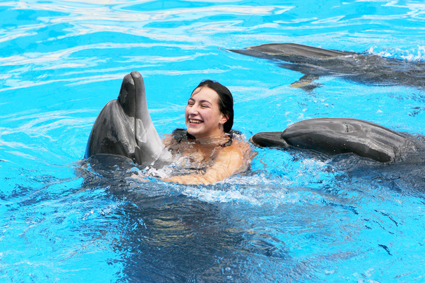 glücklich schöne junge Mädchen lacht und schwimmt mit Delfinen in blu - Foto, Bild