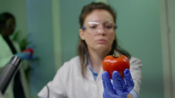 Vista frontale della ricercatrice biologa che analizza il pepe iniettato con DNA chimico - Filmati, video