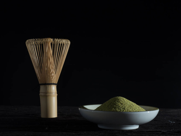 zblízka zelený čaj, sirka moc a whisk šálek horkého zeleného čaje na dřevěném stole.tradiční japonský nápoj - Fotografie, Obrázek