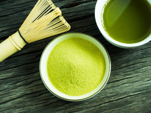 fechar o chá verde, poder matcha e bater uma xícara de chá verde quente na mesa de madeira. bebida japonesa tradicional - Foto, Imagem