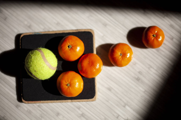 Μαύρη σανίδα και πορτοκαλί μπάλα του τένις - Φωτογραφία, εικόνα