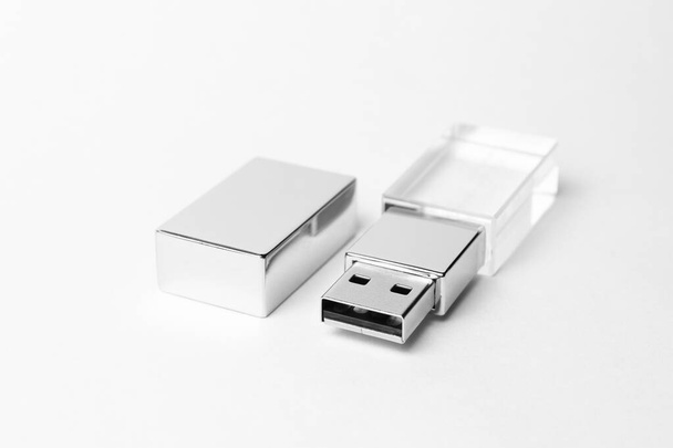 USB-Stick aus Glas mit Metallkappe auf grauem Hintergrund. Nahaufnahme. Kopierraum. Eine hohe Auflösung. Hochwertiges Foto - Foto, Bild