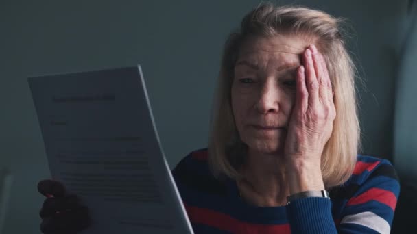 Bezorgde oudere vrouw die doktersrapport leest.  - Video
