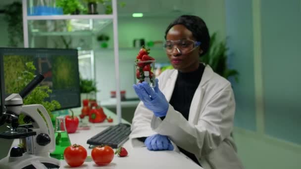 Biolog badający organiczne truskawki badające owoce - Materiał filmowy, wideo