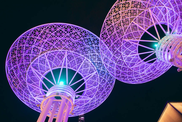 крупным планом видна знаменитая туристическая достопримечательность Дубая - футуристические светящиеся металлические супер деревья на острове голубых вод. концепция туристических направлений и технологий - Фото, изображение