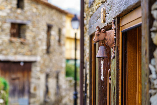 Szczegóły dzwonek drzwi z głową krowy w starej kamiennej wiosce. La Hiruela Madryt. Hiszpania. - Zdjęcie, obraz