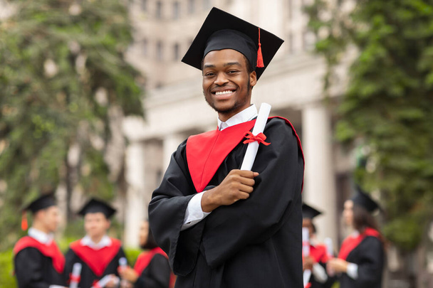 Cheerful african american guy in graduation costume - Photo, Image