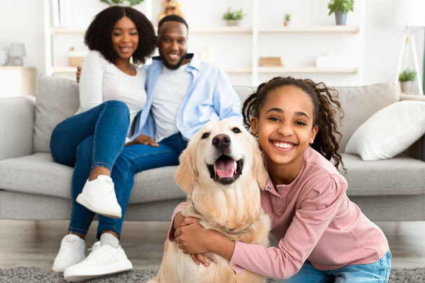 Junge schwarze Mädchen umarmen mit Hund posiert zu Hause - Foto, Bild