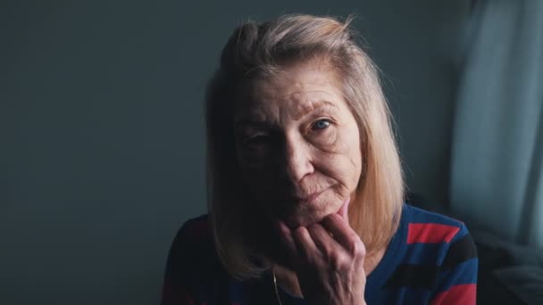 Portret van oudere vrouw met rimpels en blauwe ogen glimlachend naar de camera - Video