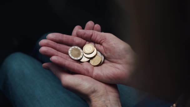 Concepto de fondos insuficientes. Pobre anciana cerrando la mano en puño con monedas - Imágenes, Vídeo