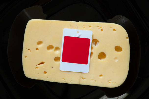 a piece of hard cheese on a black background close-up - Photo, Image