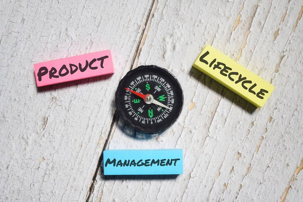Product Lifecycle Management formulering met kompas over een houten ondergrond - Foto, afbeelding