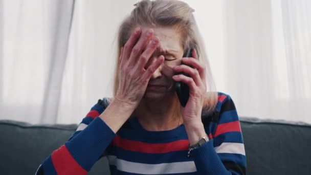 Epätoivoinen vanha nainen ottaa puhelimen keskustelun kyyneleet - Materiaali, video