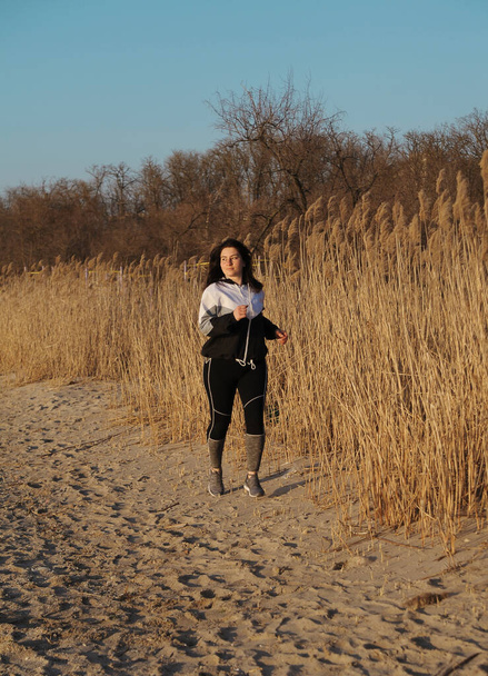 Běžící krásná mladá žena na pláži. Koncept fitness. Žena dělá cvičení venku. - Fotografie, Obrázek
