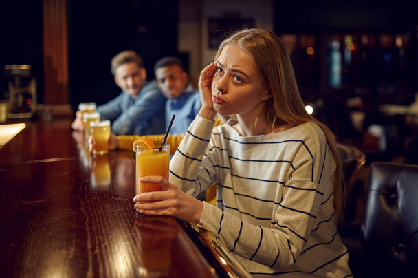 バーのカウンターでは、退屈した女の子がカクテルを飲む。人々のグループはパブでリラックス,ナイトライフ,ナイトクラブで女性の人 - 写真・画像