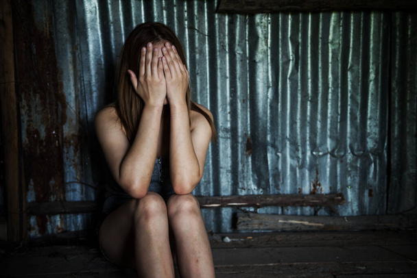 Hoffnungslos arbeitslose Frau sitzt auf Ruine Hütte oder Haus und bedeckt Gesicht an Hand, während sie weint. sie traurig und kein Weg zu gehen, weil die Arbeit entlassene Auswirkungen der covid-19-Pandemie. - Foto, Bild