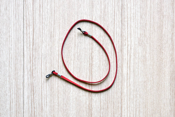 шкіряні червоні окуляри ремінець аксесуар для окулярів на дерев'яному фоні
 - Фото, зображення