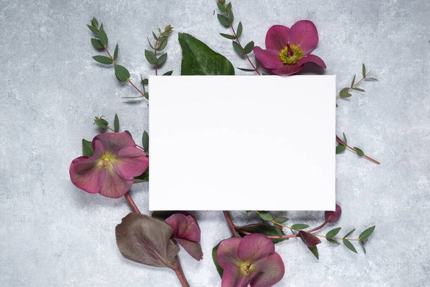 Diseño floral y tarjeta en blanco sobre un fondo gris. Concepto del día de las madres. Vista superior y espacio de copia.  - Foto, imagen