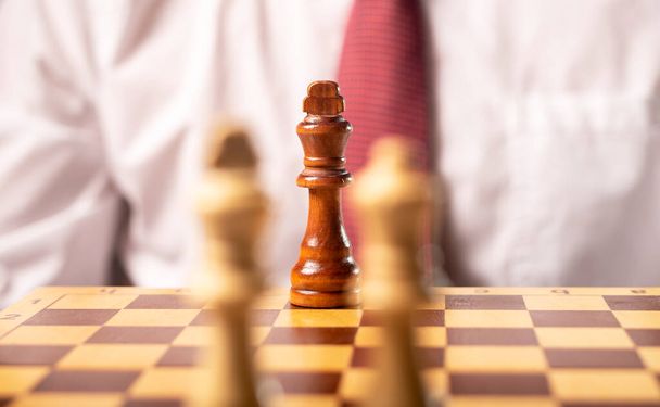 One black king against other white pieces. Battle of leaders, strategy in business - 写真・画像