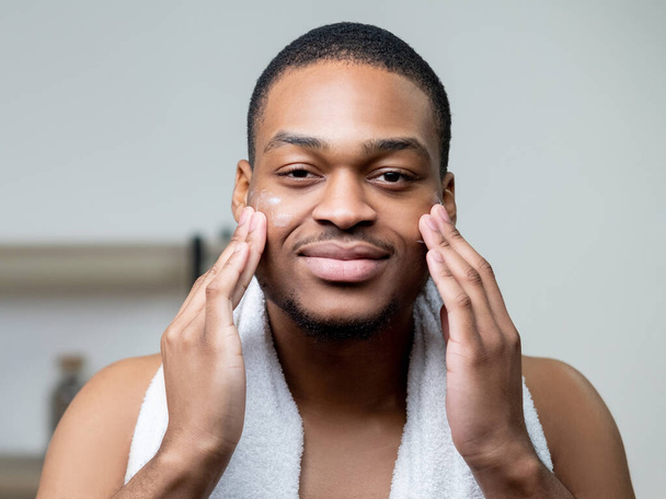 man facial care skin moisturizing applying cream - Foto, Bild