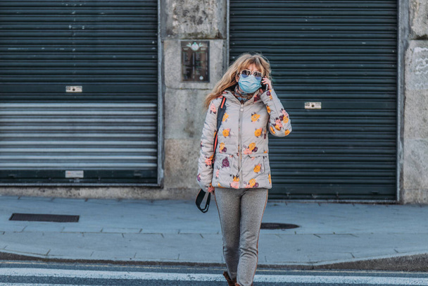 woman with mask in the city with mobile phone - Foto, afbeelding