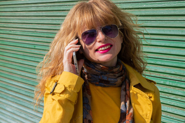 portrait de femme adulte avec téléphone portable et lunettes de soleil - Photo, image